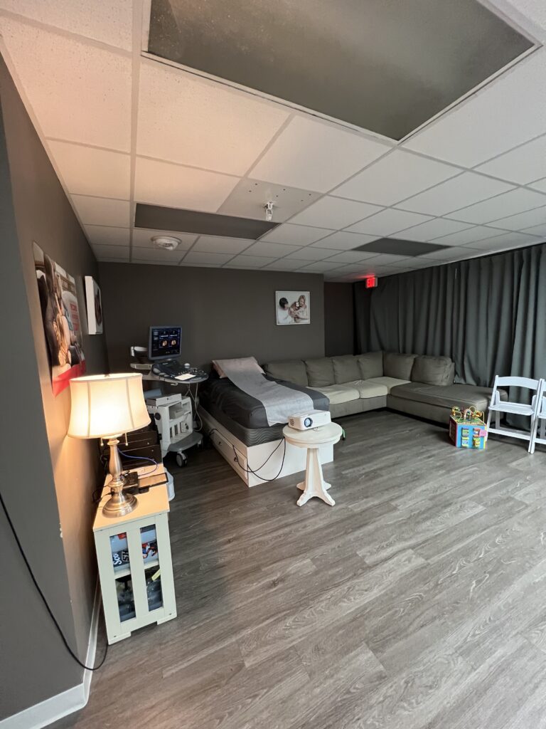 Toes to Nose ultrasound suite with a medical bed, viewing monitor, sofa and children's toys